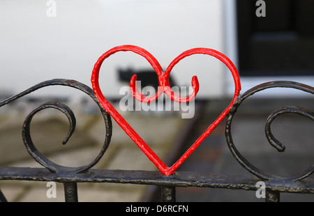 Coeur rouge peint sur un jardin à l'avant porte de fer. Banque D'Images
