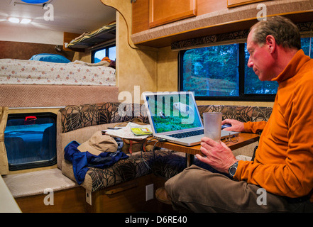 Photographe professionnel H. Mark Weidman modifier photos numériques sur un ordinateur portable à l'intérieur d'un camping-Denali National Park Banque D'Images