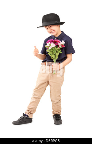 Portrait d'un mignon petit garçon avec un chapeau holding bunch of flowers, isolé sur fond blanc Banque D'Images