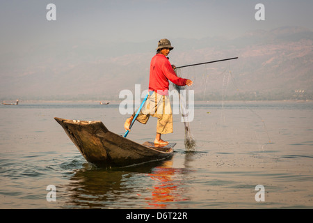 Pêcheur la pêche dans une ethnie Intha bateau de pêche traditionnel, au Lac Inle, Nyaung Shwe, l'État de Shan, Myanmar (Birmanie), Banque D'Images