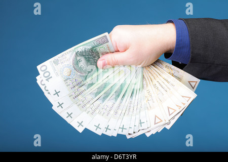 Businessman's hand holding polish argent euros fond bleu Banque D'Images