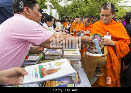 23 avril 2013 - Bangkok, Thaïlande - Thailandais place livres donnés à des projets d'alphabétisation thaïlandais en aumône des moines bols lors de la cérémonie d'ouverture à l'occasion de Bangkok comme capitale mondiale du livre 2013. L'UNESCO a décerné le titre de Bangkok. Bangkok est la 13e ville d'assumer le titre de ''capitale mondiale du livre'', en remplacement de Yerevan, Arménie. Gouverneur de Bangkok Suhumbhand Paribatra annoncé des plans que l'Administration métropolitaine de Bangkok (BMA) a l'intention d'encourager la lecture chez les Thaïlandais. L'EMA s'exécute 37 bibliothèques publiques de la ville et a modernisé 14 d'entre eux. Il prévoit de construire plus de 10 bibliothèques publiques Banque D'Images