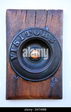 Bell porte en bois sur socle avec la presse écrite dans le milieu et les visiteurs autour de l'écrit à l'extérieur Banque D'Images