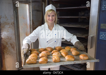 Baker mettant un comprimé de brioche ou de pain dans un four Banque D'Images