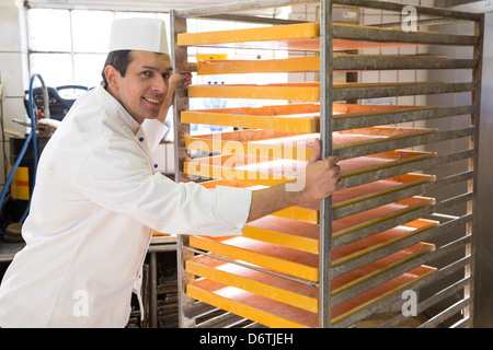 Baker avec grande grille de pain dans une boulangerie Banque D'Images