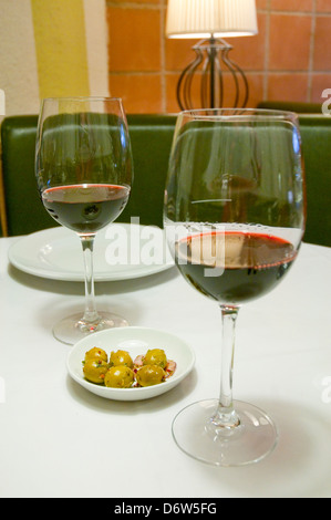 Apéritif espagnol : deux verres de vin rouge et les olives vertes. L'Espagne. Banque D'Images