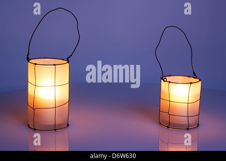 Deux lanternes confortable au crépuscule, sur fond d'hiver coloré. Banque D'Images