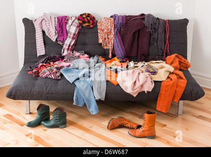 Quoi porter ? Aux vêtements en désordre sur un canapé. Banque D'Images