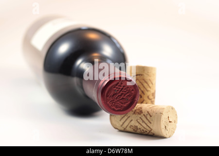 Bouchons isolés et bouteille de vin rouge avec un fond blanc Banque D'Images