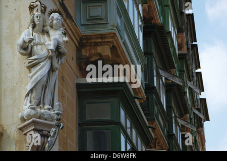 Une sculpture d'art sculpté à l'angle d'un immeuble résidentiel avec des balcons en bois typiques de la valette La capitale de l'île de Malte Banque D'Images