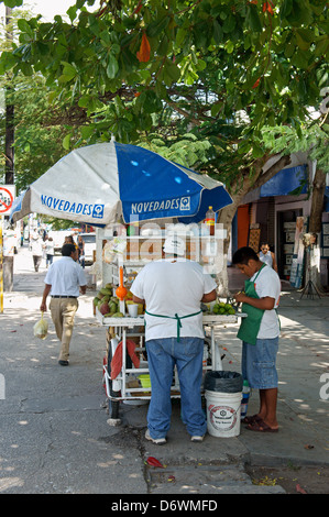 Père et fils exploité stand de fruits sur l'Avenue au centre-ville de Tulum, Cancun, Quintana Roo, Mexique Banque D'Images