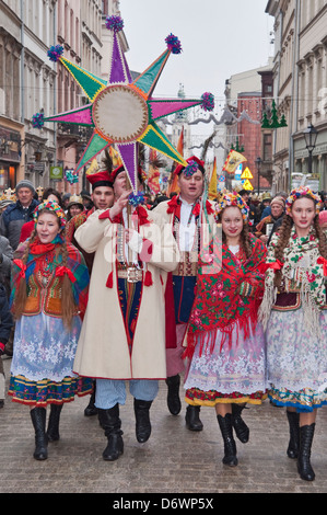 Les gens en costumes traditionnels des chants de Noël, l'exercice étoile de Bethléem, Epiphany Maison de procession, Cracovie, Pologne Banque D'Images