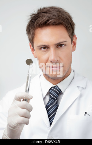 Young male Dentist Holding Tools Banque D'Images