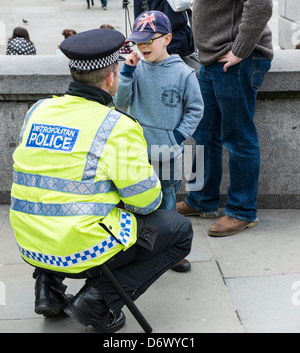 Un jeune garçon parle à un agent de police métropolitain de Londres. Banque D'Images