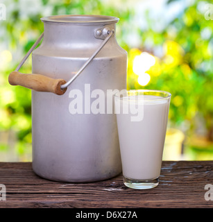 Lait en verre et aluminium sur la vieille table en bois de plein air. Banque D'Images