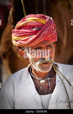 Portrait de l'Inde homme camel rider wearing red turban, Bishnoi, Inde Banque D'Images