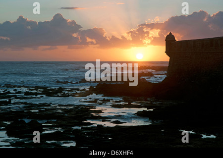 Le coucher et le château de San Sebastian, Cadix, Andalousie, Espagne Banque D'Images