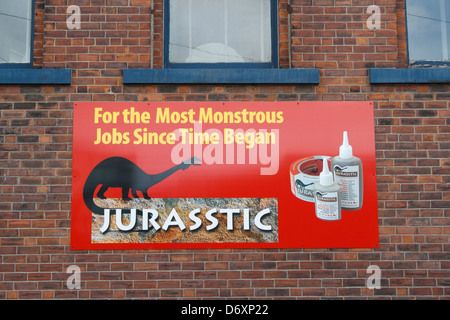 Publicité signe publicitaire sur un mur de bâtiment à Sheffield Kelham Island Angleterre Royaume-Uni. Signature de l'entreprise adhésif jurasstique Banque D'Images