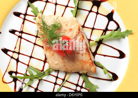 Filet de poisson poêlé Pan garnie avec la roquette et le vinaigre balsamique Banque D'Images