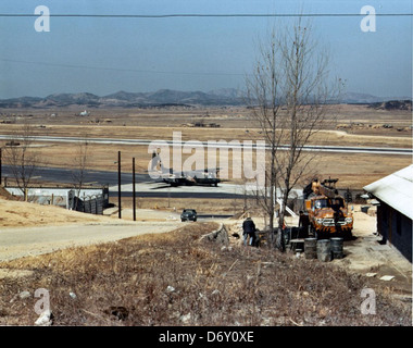La photographie de GENE Timmons prise à Osan en mars 1970 montre un Lockheed C-130 Hercules et un DC-130 Hercules, soulignant leur rôle dans l'aviation militaire. Ces avions ont été utilisés pour le transport, la reconnaissance et le contrôle de drones pendant la guerre froide. Banque D'Images