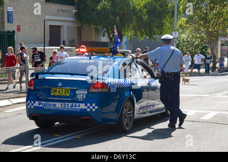 Agent de police de Sydney se tenait par sa voiture de police lors de l'ANZAC day en mars Sydney, Australie Banque D'Images