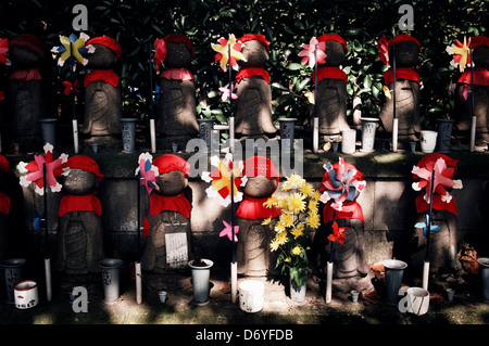 Statues Jizo Bosatsu Lignes décorées knit caps bavoirs pinwheels représentent les enfants décédés cemetery Tokyo Japon Banque D'Images