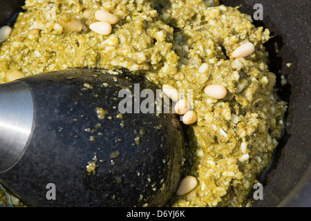 Pesto (basilic frais, huile d'olive extra vierge, le Grana Padano, noix de pin et le sel) dans un mortier avec un pilon. UK, 2013. Banque D'Images