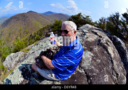 Homme plus âgé sur un rocher donnent sur l'arrêt de manger et de boire dans les Smoky Mountains. Prises avec objectif fisheye. Banque D'Images