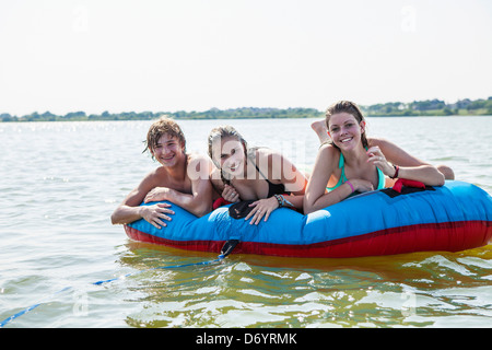 USA, Texas, Lewisville, trois adolescents sur le point de monter sur le tube intérieur dans le lac Lewisville Banque D'Images