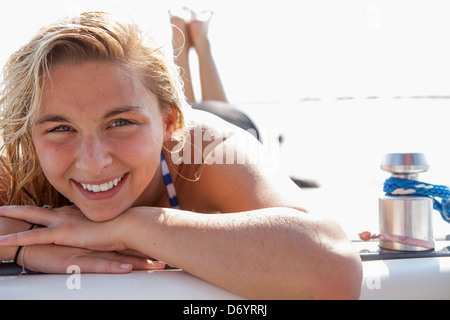 USA, Texas, Lewisville, adolescente obtenir un peu de soleil à l'arrière du bateau de ski Banque D'Images