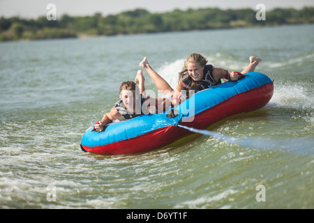 USA, Texas, Lewisville, deux adolescents équitation sur le tube intérieur dans le lac Lewisville Banque D'Images