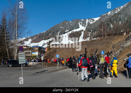 Les skieurs à pied de la parc de bus au bas de l'ascenseur en système St Anton, Autriche Banque D'Images