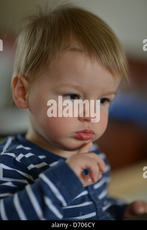 Un portrait d'un jeune garçon âgé de dix-huit mois, avec les cheveux bruns portant un déshabillé bleu et blanc dessus. Banque D'Images