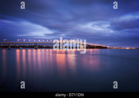 Auckland Harbour Bridge avec ses lumières sur au crépuscule. Banque D'Images