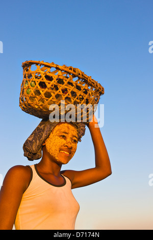 Femme (face peint avec de l'argile comme écran total) carrying basket, Morondava, Madagascar Banque D'Images