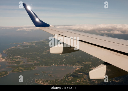 Un avion vole au-dessus de la terre et l'eau car il rend sa descente vers Boston. Banque D'Images