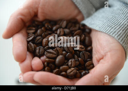 ILLUSTRATION - une femme présente des grains de café à Hambourg, Allemagne, 26 avril 2013. La chaîne allemande de magasins et de cafés, café Tchibo, investit de plus en plus dans la production durable du café vert. Photo : Marcus Brandt Banque D'Images