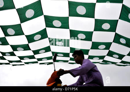 26 avril 2013 - Dungun, Terengganu, Malaisie - un garçon chevauche son vélo en vertu de l'opposition malaisienne, parti islamique malais (PAS) les drapeaux de Dungun, à quelque 300 kilomètres au nord-est de Kuala Lumpur. La Malaisie se rendront aux urnes le 5 mai. 222 Total 505 sièges parlementaires et l'état seront contestées. (Crédit Image : © Najjua ZUMAPRESS.com)/Zulkefli Banque D'Images