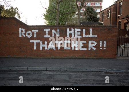 Anti-Thatcher Graffiti sur le Falls Rd, 'pourrir en Enfer Thatcher', avec Divis Appartements derrière Banque D'Images