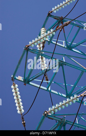 Détail d'un treillis en acier tour de transmission à haute tension avec les isolateurs électriques contre ciel bleu profond Banque D'Images