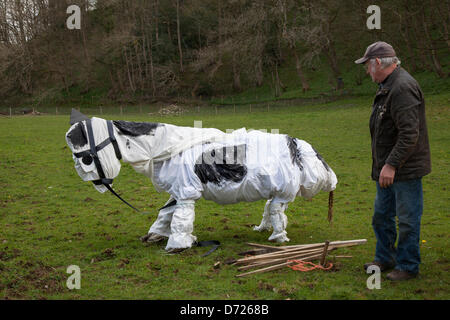 Wray, Lancaster, vendredi 26 avril, 2013. Bill Bowman, 66 avec un dessin animé peluche vache à l'Épouvantail Festival, fondé en 1995 avec wacky épouvantails construits par les villageois pour récolter des fonds pour des œuvres de bienfaisance, y compris l'église et l'école locale. Le thème pour 2013 est "J'ai lu - Livres" "culturelle" d'un point culminant de la vallée de la Lune son agenda. Des milliers de visiteurs viennent au village pour admirer le talent et l'humour de la population locale et c'est vraiment un grand affichage de l'esprit communautaire. Banque D'Images