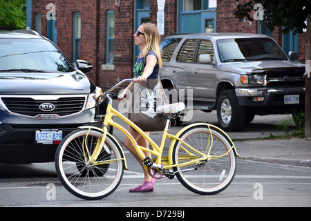 Une fille avec cycle jaune dans les rues de Toronto Banque D'Images