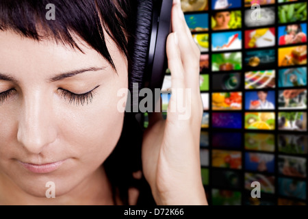 Jeune femme avec casque, bénéficiant d'une musique agréable. Banque D'Images