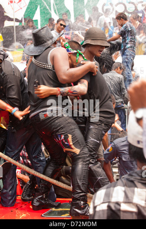 Les jeunes hommes grimpent sur les véhicules en mouvement à la danse et se font avoir par les nombreux cours d'eau au cours de la fête de l'eau Thingyan. Banque D'Images