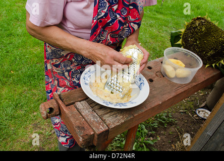 Senior woman râper éplucher des pommes de terre destructeur de l'acier Banque D'Images