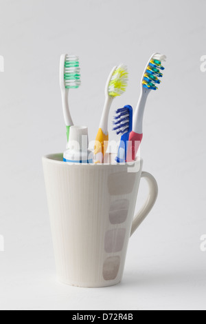 Brosses à dents et du dentifrice dans une tasse Banque D'Images