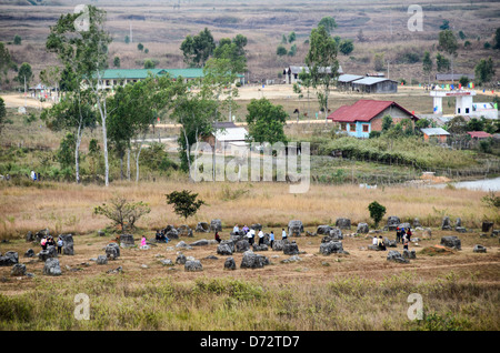 Une grappe de pots en pierre à côté de bâtiments sur la périphérie de Phonsavan au site 1 de la Plaine des Jarres dans le centre-nord du Laos. Il reste encore beaucoup à découvrir sur l'âge et l'objet de milliers de pots de pierre regroupées dans la région. La plupart des comptes à leur date au moins une couple d'il y a mille ans et théories ont été mises de l'avant qu'ils étaient utilisés dans des rituels d'inhumation. Banque D'Images