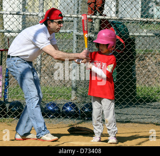 Manager Coach au bâton de l'enseignement à un raccord en t t-ball balle de baseball. Banque D'Images