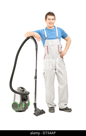 Portrait d'un homme en uniforme posant avec un aspirateur, isolé sur fond blanc Banque D'Images