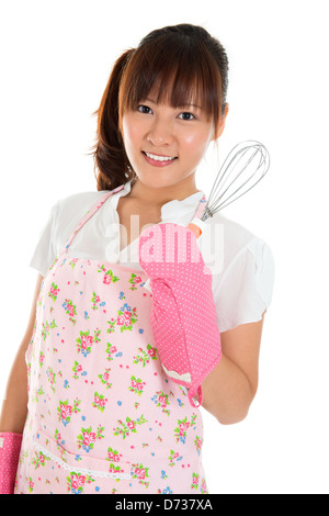 Belle Asian girl holding egg beater et sourire, isolated on white Banque D'Images